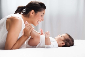 Cheerful mother playing with her baby